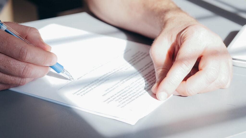 A physician signing a certificate of medical necessity (CMN) for HME DME prior authorization compliance.