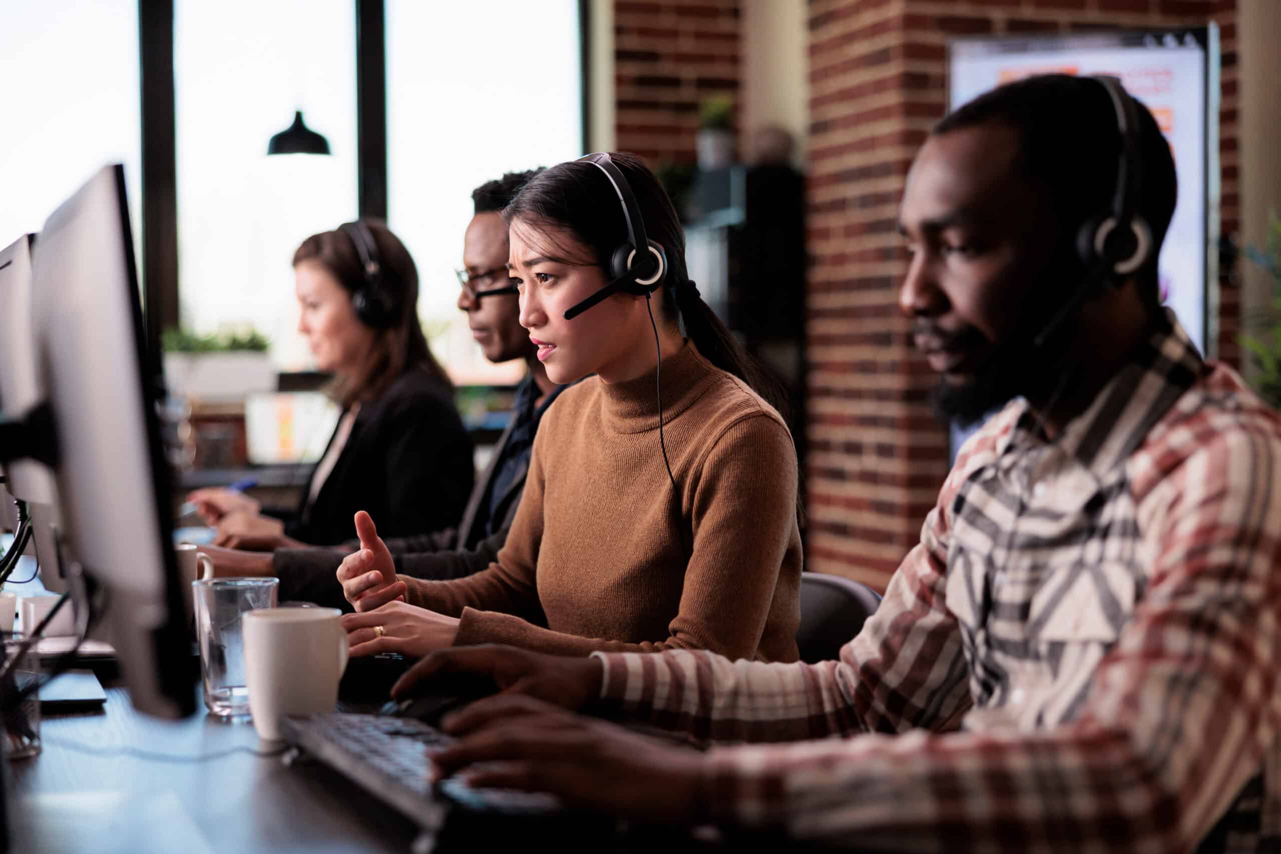 A diverse business team sitting around a conference table in an office, discussing reports and documents.