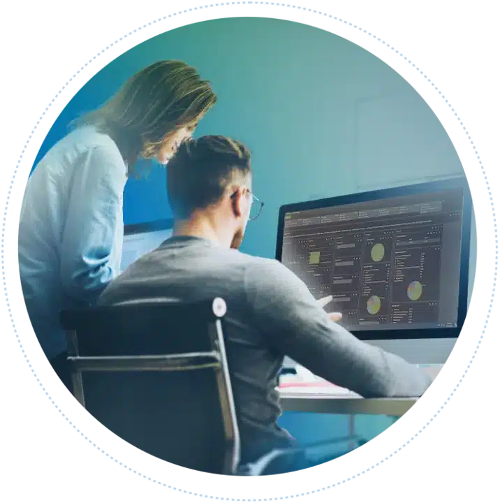 Two colleagues look at a computer dashboard displaying a complete overview of all their tracked data